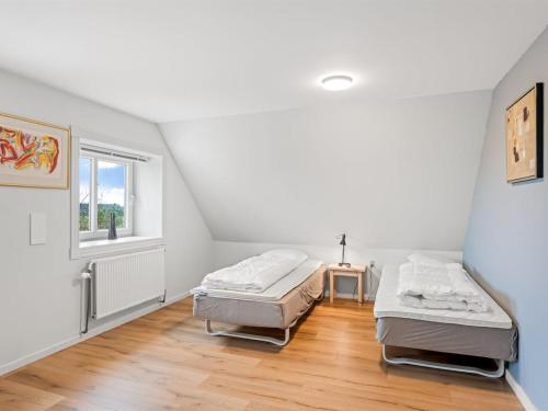 two beds in a room with a window at Holiday Home Slavomira - 12km from the sea by Interhome in Bredebro