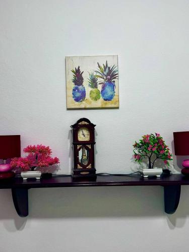 a table with a clock on a wall with flowers at Igalo Apartman Despich in Igalo