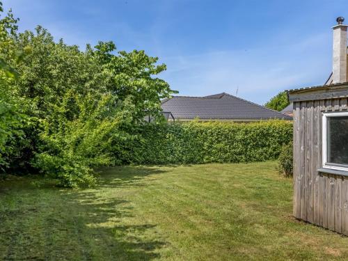 a yard with a hedge and a wooden shed at Holiday Home Slavomira - 12km from the sea by Interhome in Bredebro
