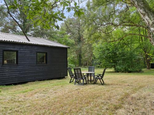 einen Tisch und Stühle vor einer Hütte in der Unterkunft Holiday Home Andresine - 1-3km from the sea by Interhome in Rørvig