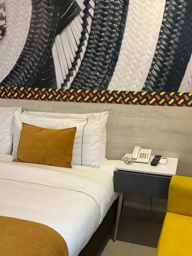 a bedroom with a bed with a phone on a table at Hotel Santa Clara Boutique in Montería