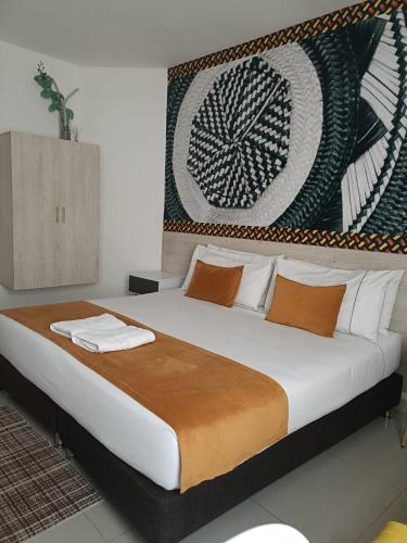 a bedroom with a large bed with a painting on the wall at Hotel Santa Clara Boutique in Montería