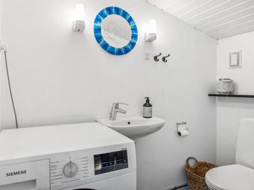 a bathroom with a sink and a clock on the wall at Holiday Home Arto - 1-2km from the sea by Interhome in Vig