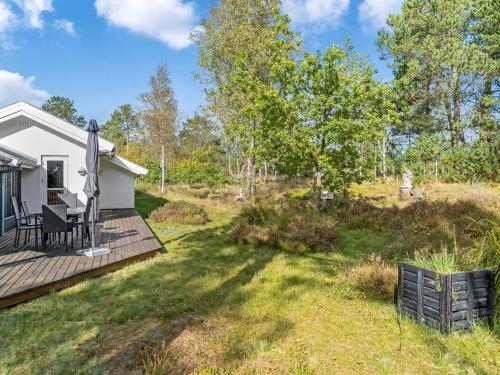 a backyard with a deck and a house at Holiday Home Reinfried - 250m from the sea by Interhome in Jerup