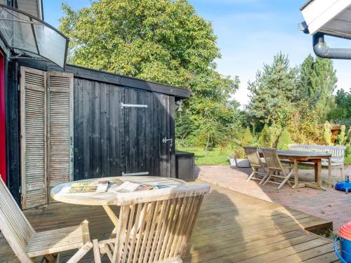 a patio with a table and chairs on a deck at Holiday Home Heraldine - 400m from the sea by Interhome in Stubbekøbing