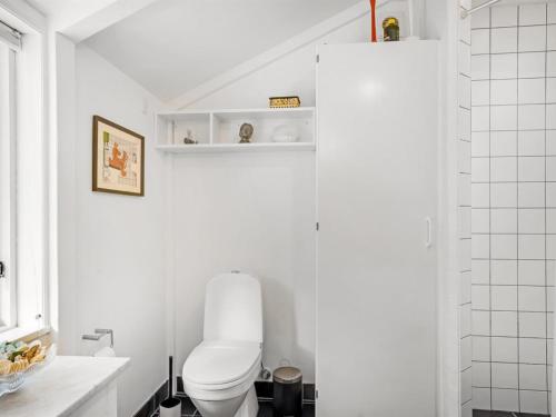 a white bathroom with a toilet and a sink at Holiday Home Reinfried - 250m from the sea by Interhome in Jerup