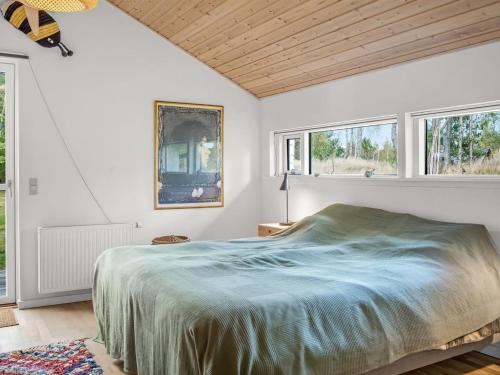 a bedroom with a large bed and windows at Holiday Home Reinfried - 250m from the sea by Interhome in Jerup