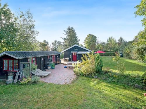 a garden with two buildings and a patio at Holiday Home Heraldine - 400m from the sea by Interhome in Stubbekøbing