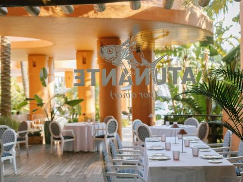 a dining room with white tables and chairs at Royal Hideaway Sancti Petri in Chiclana de la Frontera