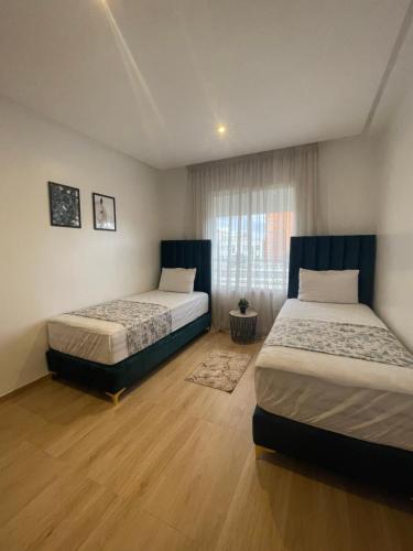a bedroom with two beds and a window at Appartement haut standing près de CHU in Oujda