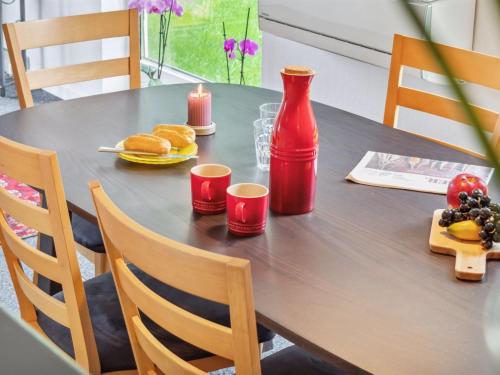 a table with a red bottle and cups on it at Holiday Home Franke - 2-1km to the inlet by Interhome in Melby