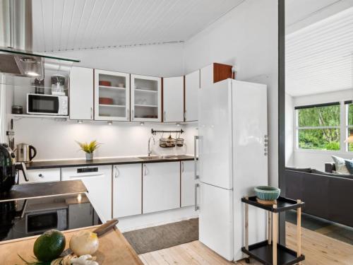 a kitchen with white cabinets and a white refrigerator at Holiday Home Franke - 2-1km to the inlet by Interhome in Melby