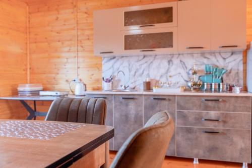 a kitchen with a counter and a table with chairs at Cottage "Labskaldi-Laila" 