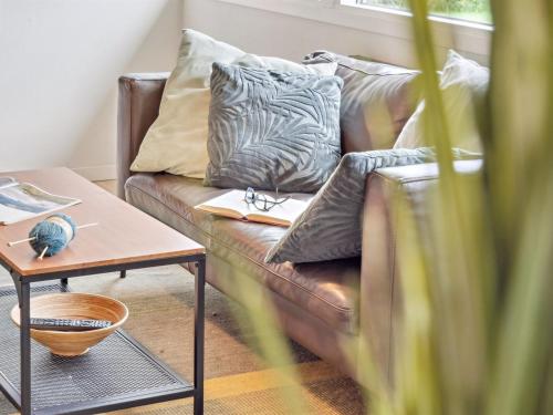 a brown leather couch with pillows and a table at Holiday Home Franke - 2-1km to the inlet by Interhome in Melby
