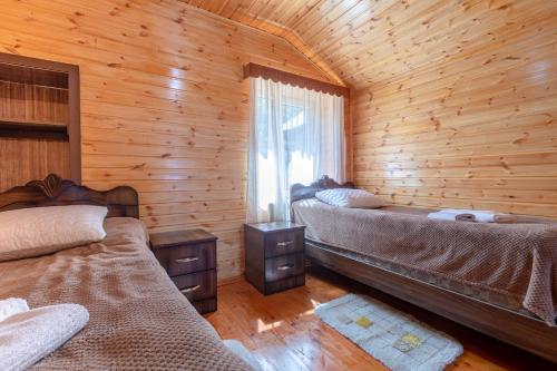 a bedroom with two beds in a log cabin at Cottage "Labskaldi-Laila" 