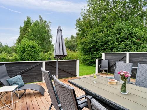 a deck with a table and chairs and an umbrella at Holiday Home Franke - 2-1km to the inlet by Interhome in Melby