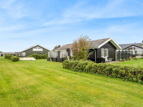 a house with a large yard in front of it at Holiday Home Snioulf - 10m from the sea by Interhome in Sæby