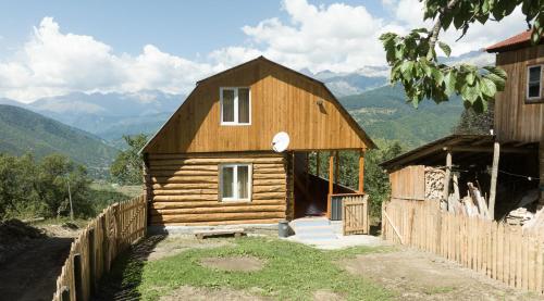 a log cabin with mountains in the background at Cottage "Labskaldi-Laila" 