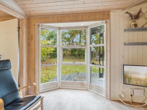 a room with a large window and a couch at Holiday Home Zezilie - 125m from the sea by Interhome in Gørlev