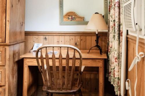 a chair sitting at a wooden desk with a lamp at The Alpenhof in Teton Village