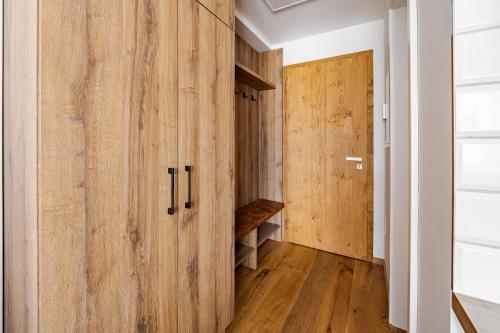 a hallway with wooden cabinets and a door at Wellness apartmán Pila Kvilda in Kvilda