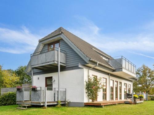 a house with a balcony on top of it at Holiday Home Elmeri - 200m from the sea by Interhome in Ebeltoft