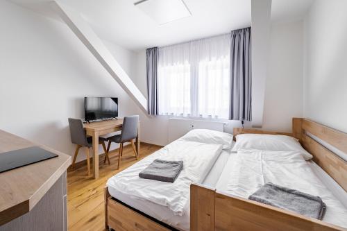 a small bedroom with a bed and a desk at Wellness apartmán Pila Kvilda in Kvilda