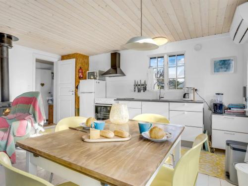 a kitchen with a wooden table with bread on it at Holiday Home Aleta - 300m from the sea by Interhome in Fakse Ladeplads