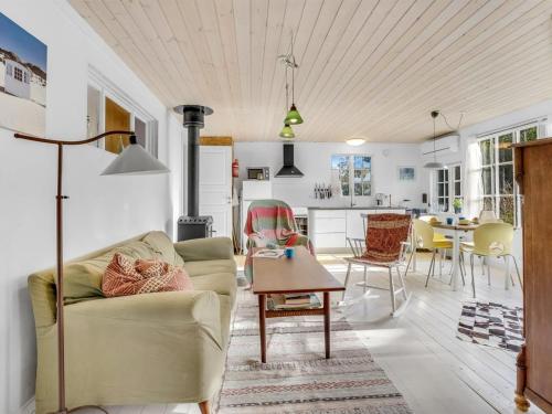a living room with a couch and a table at Holiday Home Aleta - 300m from the sea by Interhome in Fakse Ladeplads