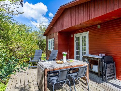 a patio with a table and chairs and a grill at Holiday Home Aleta - 300m from the sea by Interhome in Fakse Ladeplads