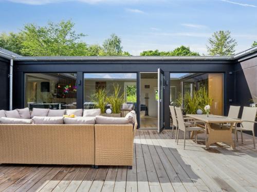 an extension of a house with glass doors and a patio at Holiday Home Aviana - 500m from the sea by Interhome in Glesborg