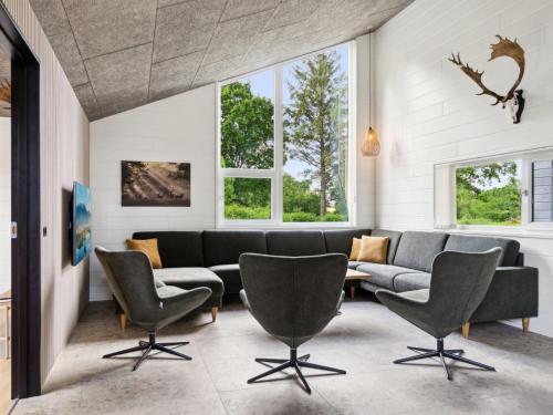 a living room with a couch and chairs and windows at Holiday Home Aviana - 500m from the sea by Interhome in Glesborg
