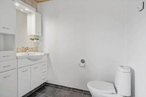 a white bathroom with a toilet and a sink at 70751-Ulfborg-Fjordvaenget-13 in Thorsminde