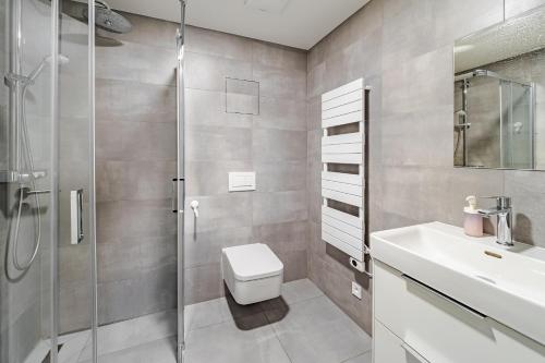 a bathroom with a shower and a toilet and a sink at Wellness apartmán Pila Kvilda in Kvilda