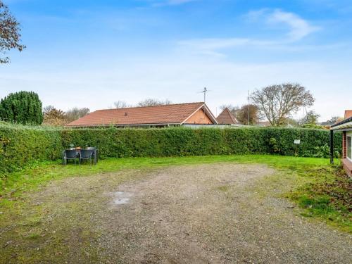 a yard with a hedge and a house at Apartment Kamp - 1km to the fjord by Interhome in Ringkøbing