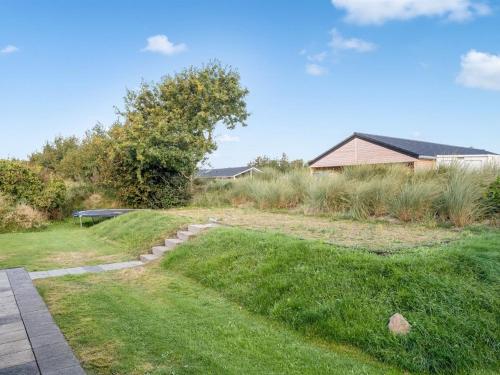 a grassy yard with a house in the background at Holiday Home Billa - 450m from the sea by Interhome in Blåvand