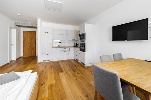 a kitchen with a dining table and a television on the wall at Wellness apartmán Pila Kvilda in Kvilda