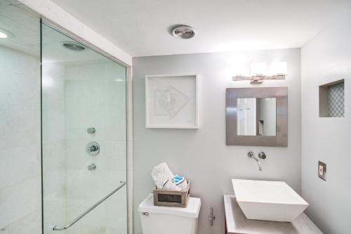 a bathroom with a shower and a toilet and a sink at Dtwn Cleveland Loft-Style Condo Walk to Stadiums! in Cleveland