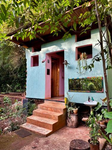 a blue house with a staircase leading to a door at Jinja Jungle Glamping Tent 2025 in Jinja