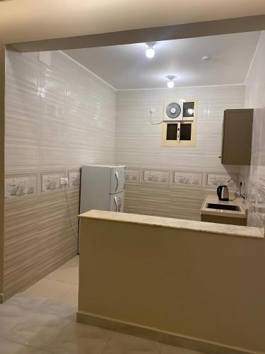 a kitchen with a counter and a refrigerator at شقق جوهرة الخميس للشقق المخدومة in Khamis Mushayt