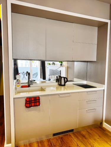 a kitchen with white cabinets and a sink at Annabelle Studio in Batumi