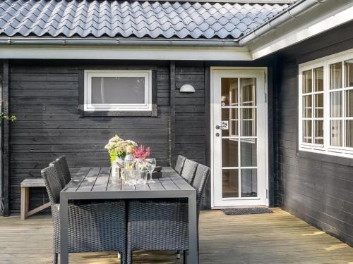 a table on a patio with chairs and a door at Holiday Home Evi - 500m from the sea by Interhome in Jerup