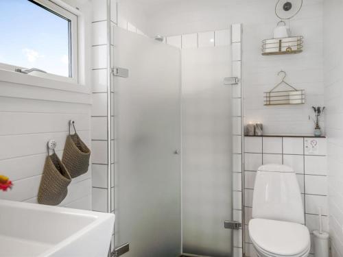 a white bathroom with a toilet and a sink at Holiday Home Evi - 500m from the sea by Interhome in Jerup