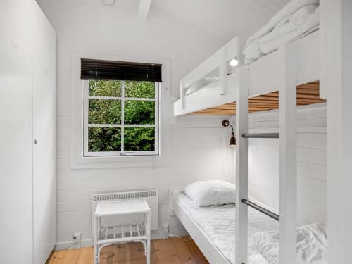 a bedroom with two bunk beds and a window at Holiday Home Evi - 500m from the sea by Interhome in Jerup