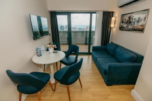 a living room with a couch and a table and chairs at Batumi River Source in Batumi