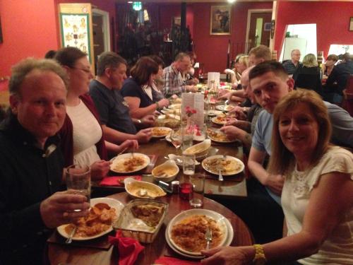 a group of people sitting at a long table eating food at The Woolaston Inn in Lydney