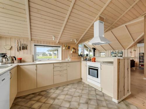 a large kitchen with white cabinets and a window at Holiday Home Märta - 250m from the sea by Interhome in Lemvig
