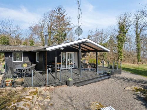 a black house with a porch with a table and chairs at Holiday Home Caren - 75m from the sea by Interhome in Allinge