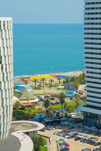 a view of a city with a parking lot and the ocean at Batumi River Source in Batumi