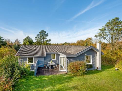 a blue house with a table in a yard at Holiday Home Pirjo - 350m to the fjord by Interhome in Skjern